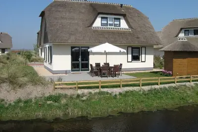 Image de Maison au toit de chaume bien entretenue avec tout le confort, près de la plage