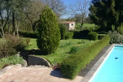 Image de Grande maison sur deux étages avec piscine et jardins.