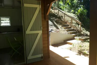 Image de Sainte Rose : villa en bois avec terrasse entourée de végétation, très calme