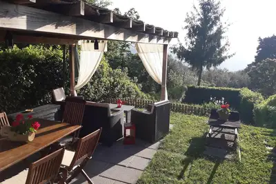 Image de Grande partie de l'ancienne maison de campagne en pierre sur les collines au nord de Lucques avec vue panoramique. Jardin.