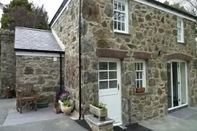 Image de Y Bwthyn est situé sur une voie privée tranquille dans le domaine d'une plus grande maison.