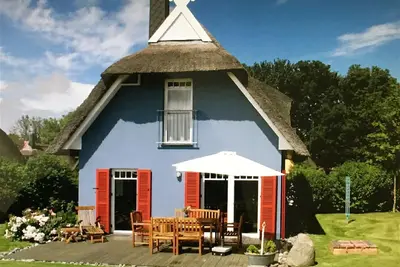 Image de maison de chaume élégante avec beaucoup de soleil, de luxe, grand jardin et vue sur le phare