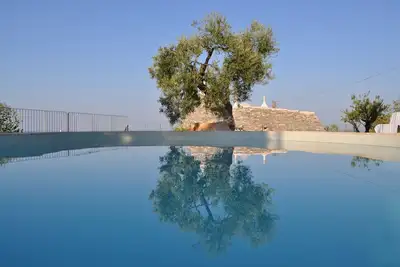 Image de Luxueuse maison Trullo avec piscine, salon et salle à manger extérieurs
