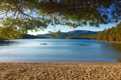 Image de Boathouse Cottage sur une grande plage privée avec vue sur le coucher du soleil, la montagne et le lac