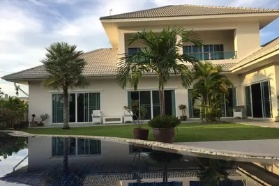 Image de villa de luxe moderne avec une grande piscine d'eau salée, un jacuzzi et un jardin tropical