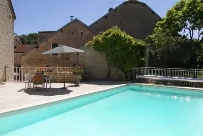 Image de Conversion de grange conçue par un architecte avec piscine chauffée, bordures champagne / bourgogne