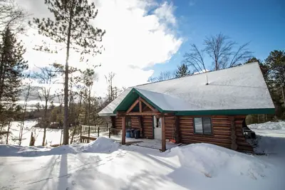 Image de Motoneigistes et skieurs Accueil en bois rond scandinave complet sur un lac privé