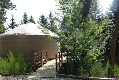 Image de 1 yourte contemporaine tout confort située dans un bois en terrasse avec vue.