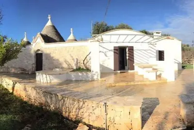 Image de Trullo entier fantastique avec piscine immergé dans la paix des oliviers, réservé