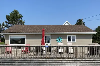 Image de Chalet mignon avec vue sur l'eau. Étapes vers une plage de sable rouge sur la Rive-Sud.