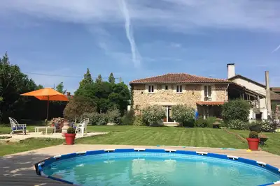 Grande maison de campagne bien entretenue avec un grand jardin et une pataugeoire.