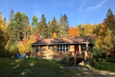 Image de Maison du Pain de Sucre, propre, entourée de sapins, de la faune,