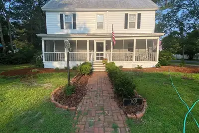 Image de Historique Methodist Parsonage. . . . Avec un Front Porch complet des Rockers et histoires!