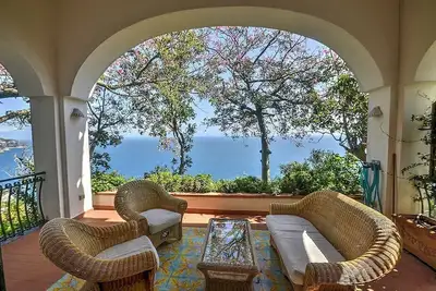 Image de Villa Rachele: Une charmante villa de deux étages construite sur un terrain en pente faisant face à la mer.