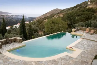Image de Sur une colline luxuriante, une maison de campagne isolée avec piscine à débordement et vue sans fin