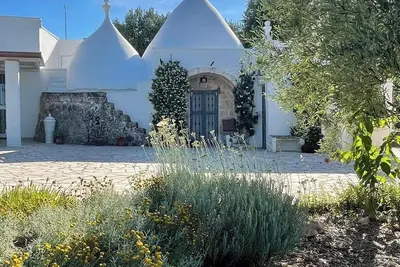 Image de Beau trullo avec piscine d'eau salée niché dans sa propre oliveraie et ses jardins