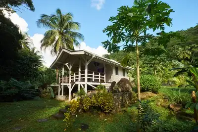 Cottage pierres et bois en bord de rivière dans jardin