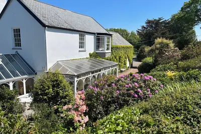 Image de Extension géorgienne au manoir Tudor situé dans 2 1/2 acres sur un chemin côtier