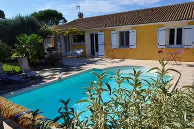 Image de Jolie maison avec jardin paysagé et piscine privative.