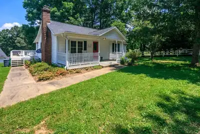 Image de Cottage de style ferme blanc classique parfait pour une escapade sereine à la campagne