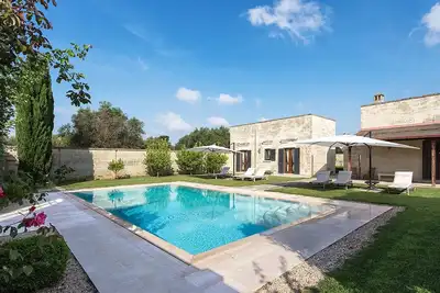 Image de Masseria La Rosa avec piscine à débordement entourée d'oliviers dans les Pouilles