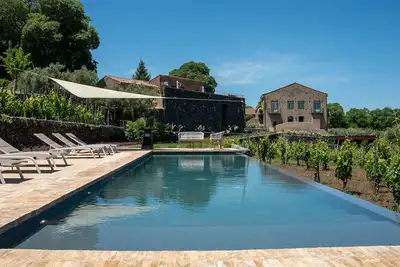 Image de Borgo Rovittello, maison traditionnelle sicilienne immergée dans les vignes.