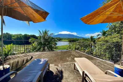 Image de Spectacular Island Retreat avec piscine et tennis niché dans un cadre tropical.