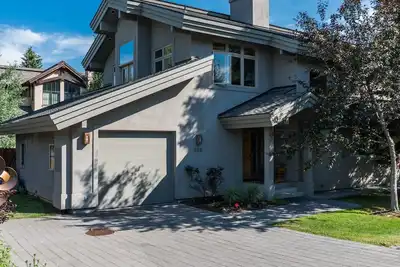 Maison en rangée sur une rue privée près d'une piste cyclable, d'une rivière et d'une ville.
