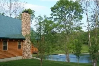 Image de Cabane en rondins de luxe isolée donnant sur un bel étang ensemencé