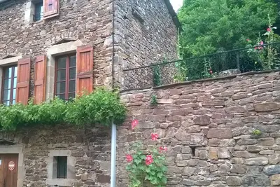 Image de maison individuelle avec jardin attenant, dans petit village entouré de forets.
