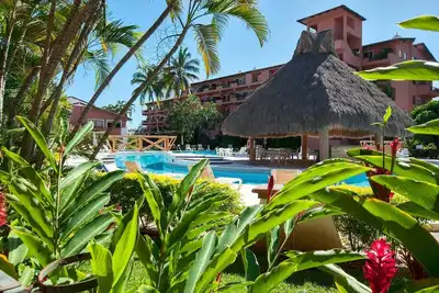 Image de Condo central et confortable avec piscine et patio privé ensoleillé.