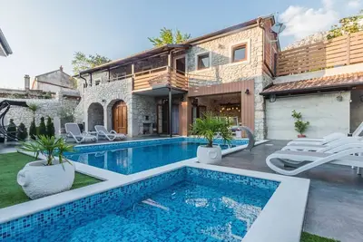 Image de Villa de luxe en pierre avec piscine chauffée, bassin pour enfants et cour à la campagne