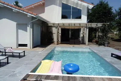 Image de belle maison contemporaine sur terrain arboré avec piscine et pool house