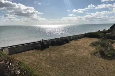 Image de Maison pieds dans l'eau sur la plage avec grand jardin