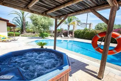 Image de Villa spacieuse, grande piscine privée, jacuzzi extérieur, jardins attrayants, à 10 minutes à pied de la plage!