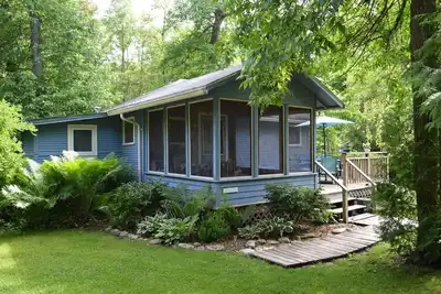Image de Évadez-vous dans ce chalet pittoresque niché derrière un beau lit de fougère.