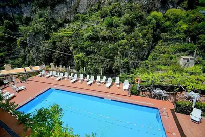 Appartamento Ulisse G: Un cottage caractéristique entouré de verdure.