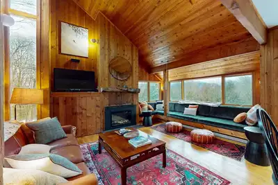 Image de Maison de ski dans les bois avec bain à remous privé, cheminée et vue sur la montagne