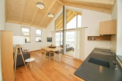 Chalet de vacances avec véranda couverte avec mobilier de salon et chaise longue flottante.