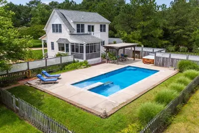 Image de Chalet en bord de mer haut de gamme avec une piscine et un bain à remous pieds de la porte arrière.