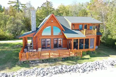 Image de maison de bois rond sur la plage de sable du lac Huron