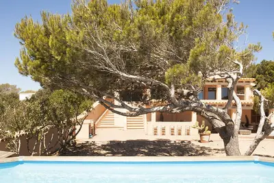 Image de Villa à Cala en Baster avec vue sur la mer et piscine entourée d'une pinède