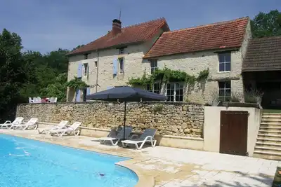 Maison de caractère avec piscine et jardin arboré.