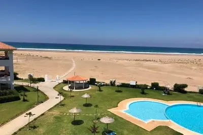 Image de Asilah Beralmar, les pieds sur la plage, avec Ahmed