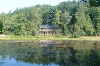 Image de Maison en pierre isolée avec une terrasse de 50 'donnant sur le lac Beaver sur une ferme de champignons.