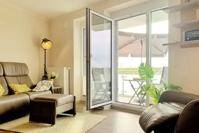 Image de appartement moderne directement sur la digue de la mer du Nord avec une chaise de plage