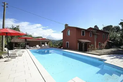 Image de Villa Ebano: Une charmante villa de deux étages entourée de verdure.