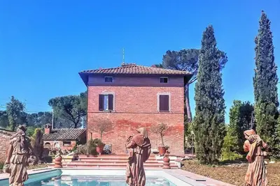 Image de Villa Eloisa: Une villa historique sur trois étages entourée de verdure.