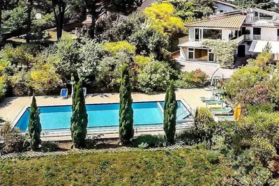 Image de Villa Begonia: Un charmant appartement qui fait partie d'une villa de deux étages située au sommet d'une petite colline.