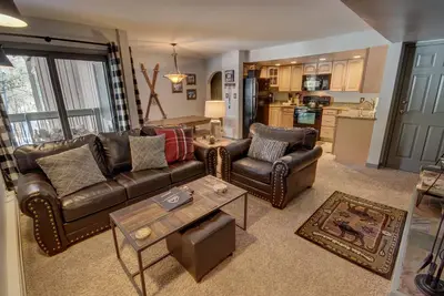 Image de Ce condo est situé dans le joli quartier de West Keystone. Ce salon est confortable avec une cheminée à bois et une grande télévision à écran plat. Le canapé se transforme en un lit de taille normale pour un sommeil supplémentaire. La cuisine est mise. .